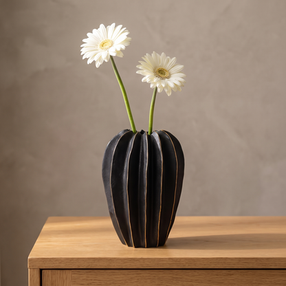 Black ribbed carambola ceramic vase displayed in a warm modern interior