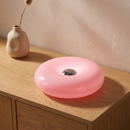 Blush donut table lamp displayed in a warm modern interior