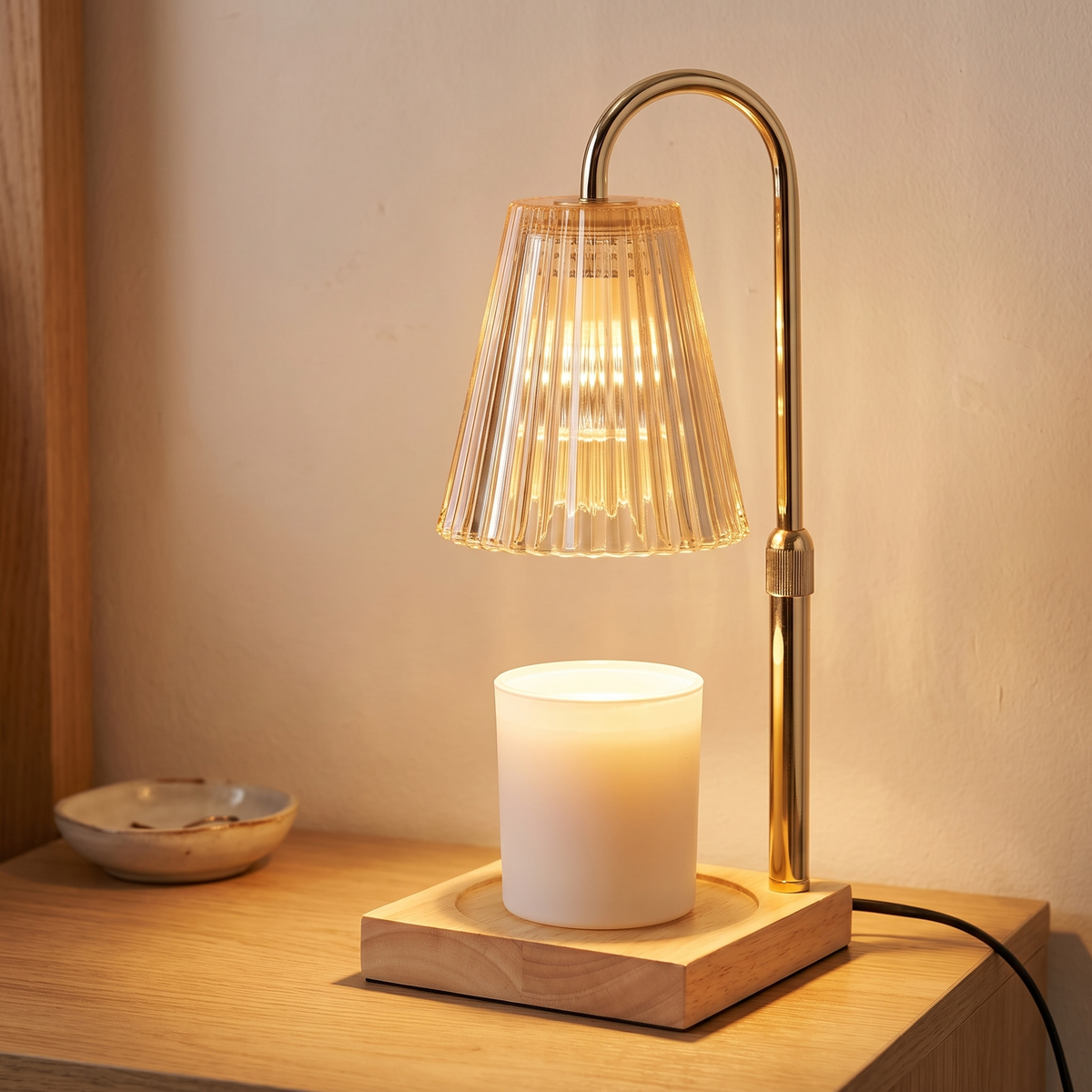 Gold candle warmer lamp with wooden tray displayed in a warm modern interior