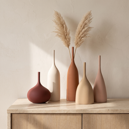 Handmade Morandi ceramic vases grouped on a travertine sideboard with dried pampas