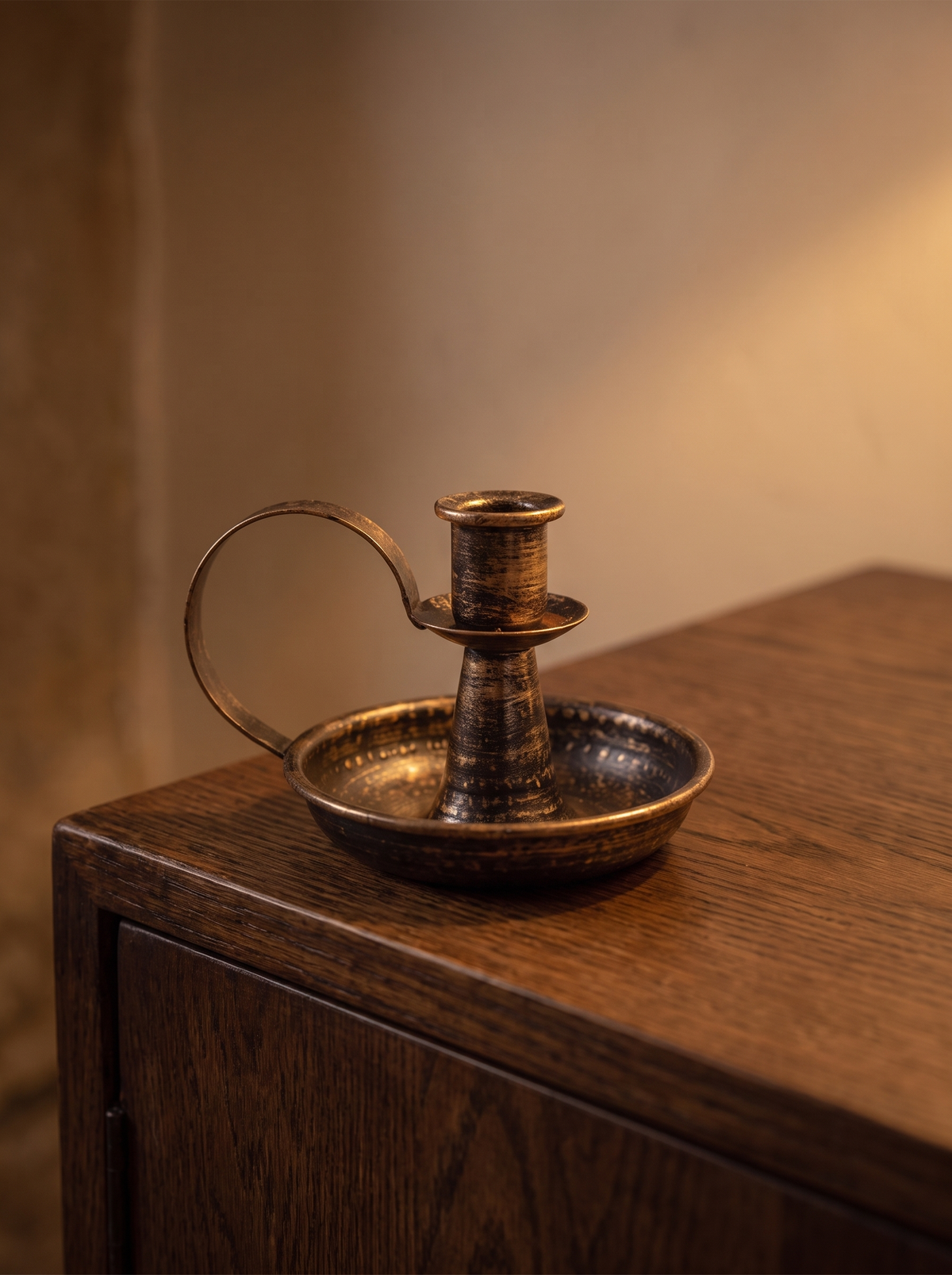 Iron candle holder with curved handle on a sideboard