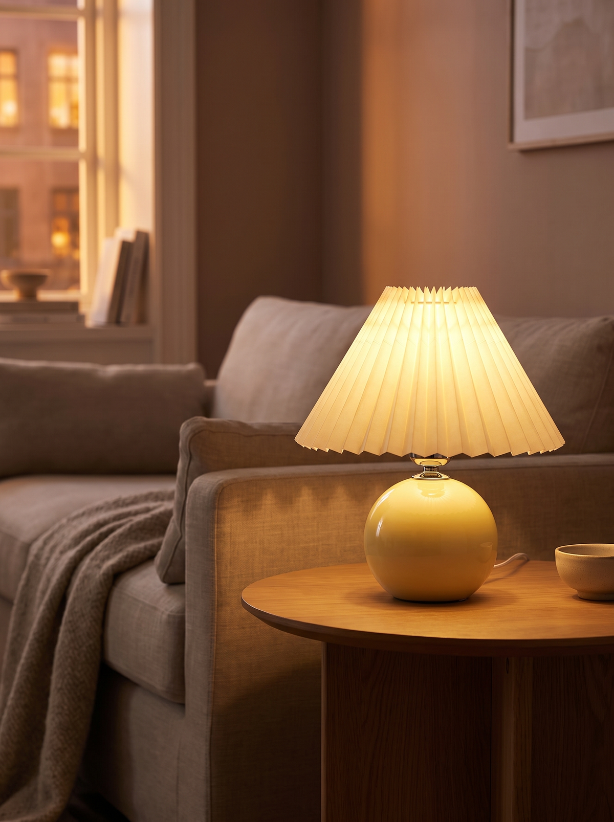 Ceramic pleated lamp lit on a side table