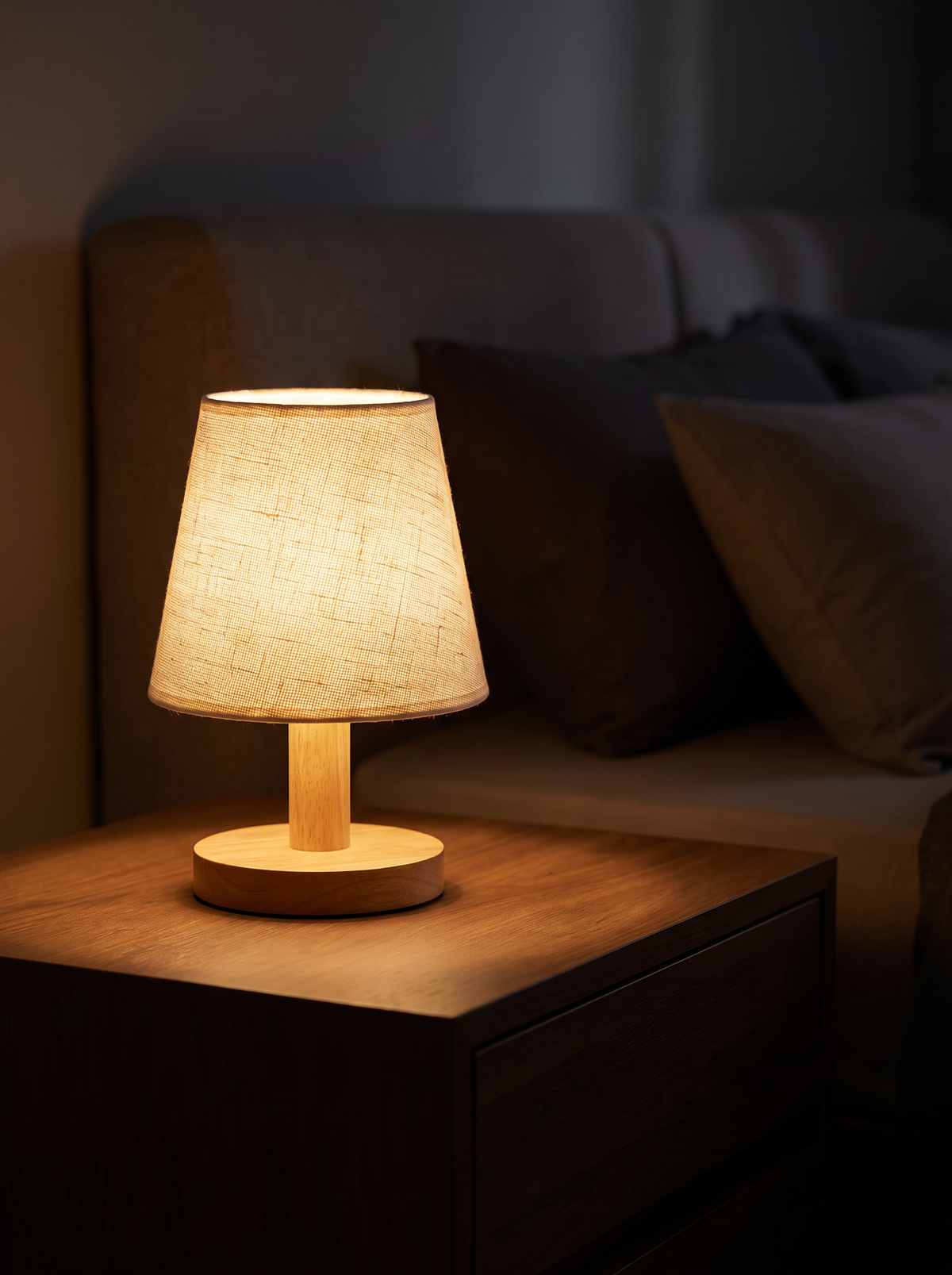 Wooden bedside lamp lit warm at night