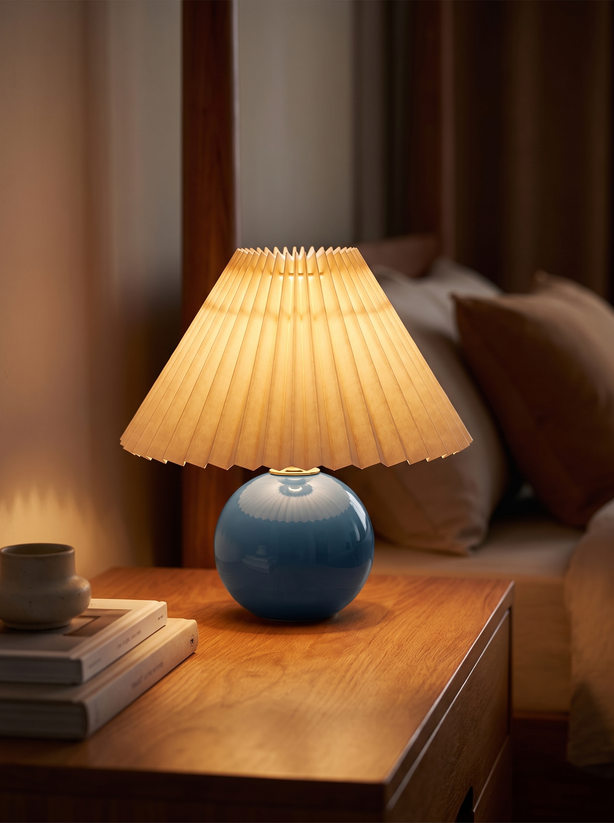 Ceramic table lamp lit warm on a desk