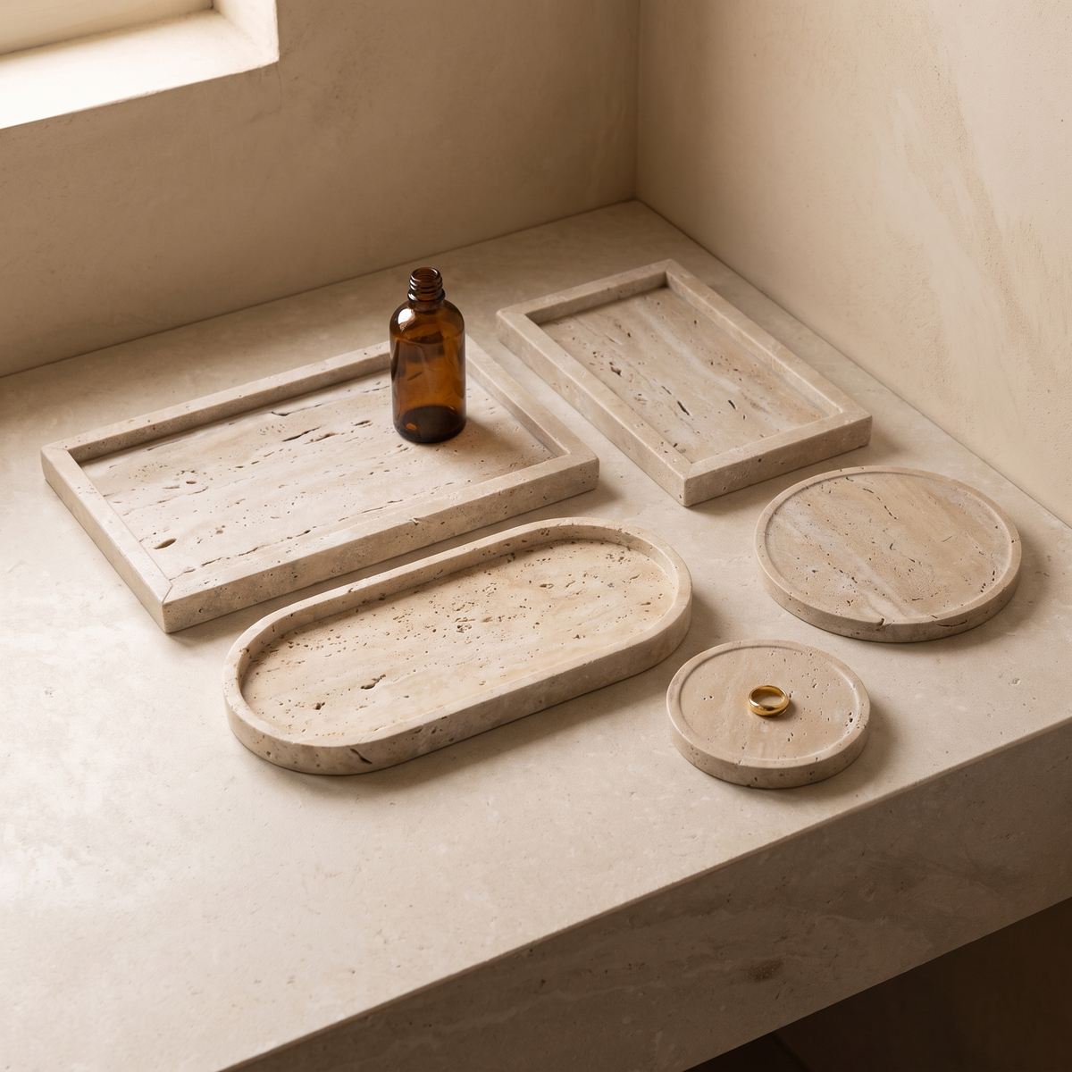 All five natural travertine vanity tray sizes together on a limestone vanity