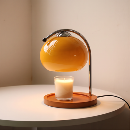 Orange glass candle warmer lamp displayed in a warm modern interior