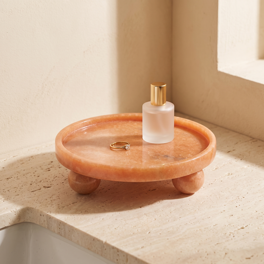 Round red jade stone tray on ball feet displayed in a warm modern interior
