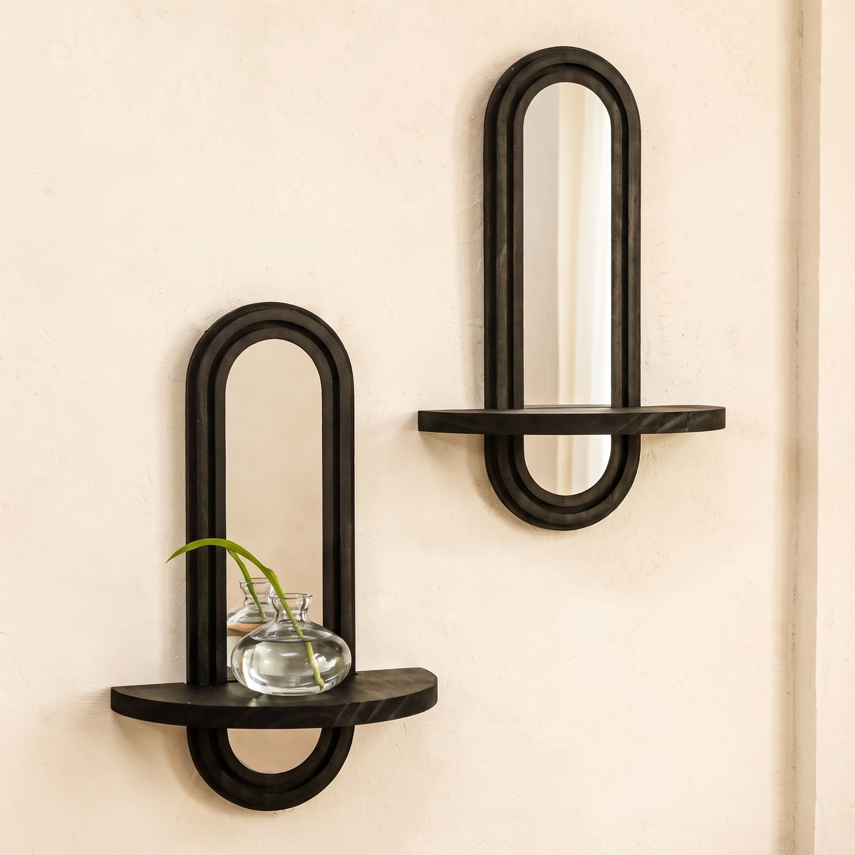 Set of two black arched wall mirrors with shelves displayed in a warm modern interior
