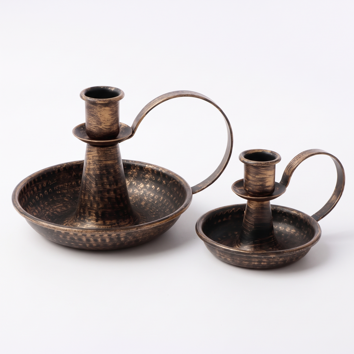 Set of two bronze hammered iron candle holders on a white background